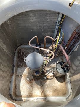Cleaned AC compressor and refrigerant lines inside a condensing unit