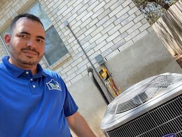 BB&M AC and Heating technician beside an air conditioning unit during a service visit