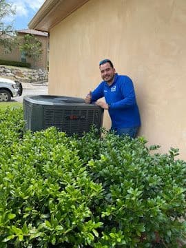 Completed residential air conditioner installation beside a stucco home