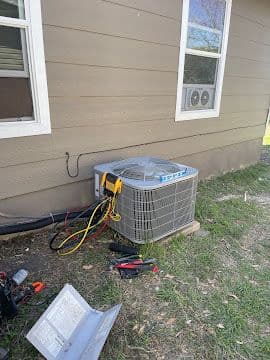 AC condenser connected to refrigerant gauges during a diagnostic service call