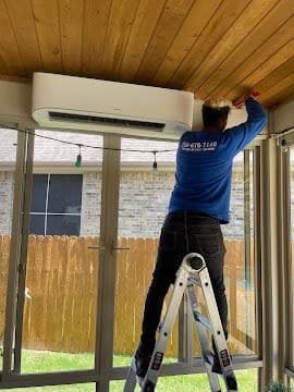 Technician installing a ductless mini split air handler on a covered patio