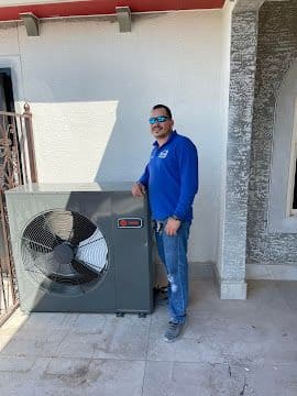 Technician standing beside a newly installed mini split heat pump condenser
