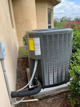 New high-efficiency AC condenser installed with fresh line set and disconnect
