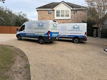 Two BB&M AC and Heating service vans parked at a residential HVAC job